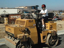 Brad on construction equipment outside new high school
