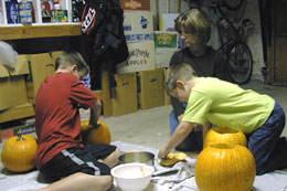 Brad, Kristi and Doug carve pumpkins in the garage